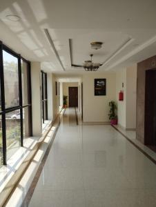 an empty hallway in a building with a large window at ANNAI RESIDENCY in Vellore