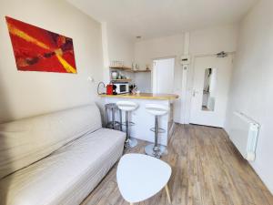 a living room with a couch and a kitchen at Allen - 2min de la plage du sillon et intra in Saint Malo