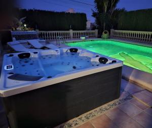 a hot tub in front of a pool at night at Luxury Villa - pool, hot tub, aircon, TVs, home cinema, office, Gbit Internet, sports equipment, car in Calpe