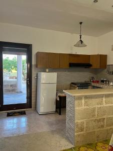a kitchen with a white refrigerator and a counter at Dimora Mimmi Marina di Mancaversa - Gallipoli in Marina di Mancaversa