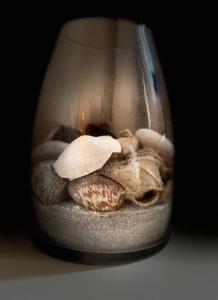 ヴァーネミュンデにあるApartments in Warnemuendeの貝殻とろうそくが詰まったガラス瓶