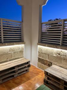 two wooden benches in a room with two windows at Dimora Mimmi Marina di Mancaversa - Gallipoli in Marina di Mancaversa