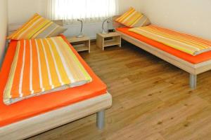 2 camas en una habitación con suelo de madera en Ferienwohnung Landblick Rastede, en Rastede