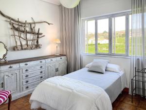 een slaapkamer met een bed, een dressoir en een raam bij Camino del Soplao -zona Santillana del Mar- in Reocín