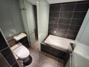 La salle de bains est pourvue de toilettes, d'un lavabo et d'une douche. dans l'établissement Bentley Hotel, à Zhongli