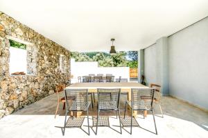 a dining room with a stone wall and a table and chairs at Kumquart estate- Bergamot in Aspiotádes