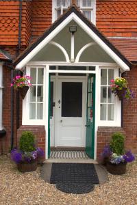 a front door of a brick house with flowers at Gatwick Turret Guest House in Horley