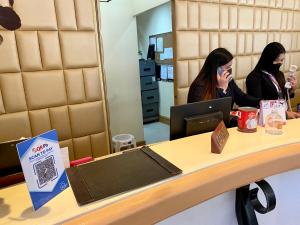 two women sitting at a counter talking on a cell phone at Maharaja Oriental Suite Makati in Manila +82 photos