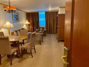 a living room with a table and chairs and a couch at Maharaja Oriental Suite Makati in Manila