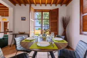 uma sala de jantar com uma mesa de madeira e cadeiras em The Olympians Villas em Polis Chrysochous