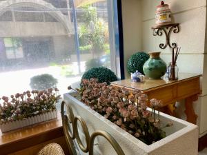 a room with a window with a table with flowers at Maharaja Oriental Suite Makati in Manila