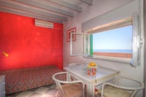 une chambre rouge avec une table et une fenêtre dans l'établissement Ferienwohnung für 6 Personen ca 50 qm in Giardini Naxos, Sizilien Ostküste von Sizilien, à Giardini Naxos