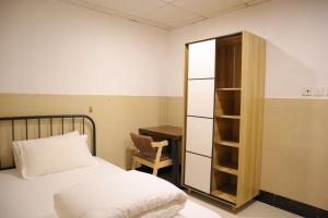 sypialnia z łóżkiem, krzesłem i biurkiem w obiekcie Comfort Hostel w Hongkongu