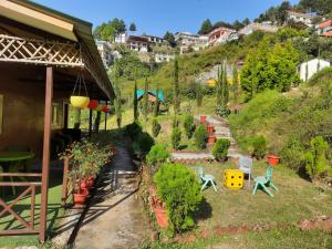 a garden with chairs and plants next to a house at Cascade Resort And Cottages in Mussoorie