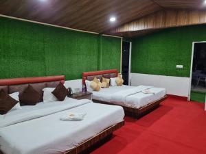 2 camas en una habitación con paredes verdes en Cascade Resort And Cottages en Mussoorie