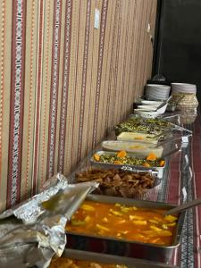 una línea de buffet con muchos tipos diferentes de comida en Wadi Rum Magic Camp en Wadi Rum