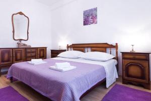 a bedroom with a bed with a purple blanket at Ferienwohnung für 6 Personen ca 85 qm in Trogir, Dalmatien Kaštela und Umgebung in Trogir
