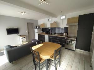 a kitchen with a wooden table and a couch at La Chaloupe gites de mer in Jullouville-les-Pins +19 photos