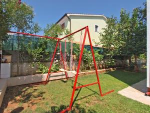 een rode schommel in de tuin van een huis bij Ferienwohnung für 4 Personen ca 45 qm in Valbandon, Istrien Istrische Riviera - b54955 in Valbandon