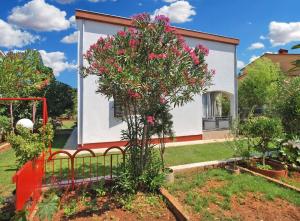 een boom met roze bloemen voor een huis bij Ferienwohnung für 4 Personen ca 45 qm in Valbandon, Istrien Istrische Riviera - b54955 in Valbandon