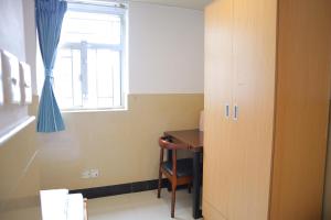 a room with a desk and a window and a table at Comfort Hostel in Hong Kong