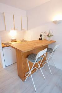 eine Küche mit einer Holztheke mit zwei Stühlen in der Unterkunft Hossegor - Vue Océan - Plage - Couple - Enfant in Soorts-Hossegor + 4 Fotos