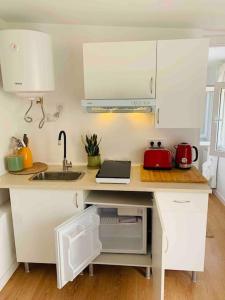 a kitchen with white cabinets and a counter with a sink at Casita privada in Alpedrete