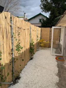 a wooden fence next to a house with a patio at Casita privada in Alpedrete