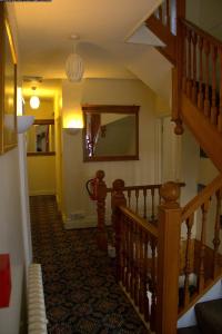a stairway leading up to a room with a fire place at Gatwick Turret Guest House in Horley