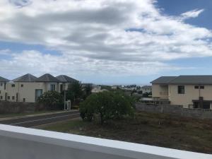 a view of a road with houses in the background at AlexJ Residence in Flic-en-Flac