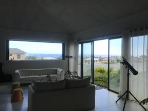 a living room with a couch and large windows at AlexJ Residence in Flic-en-Flac +2 photos