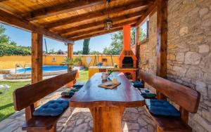 een patio met een houten tafel en banken bij Ferienwohnung für 5 Personen ca 60 qm in Mali Vareski, Istrien Südküste von Istrien in Mali Vareški