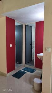 Divine Gift Coorg Homestay في Suntikoppa: حمام بجدران حمراء ومغسلة ومرحاض