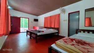 Divine Gift Coorg Homestay في Suntikoppa: غرفة نوم بسريرين وطاولة فيها