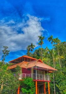 a building with palm trees in the background at Divine Gift Coorg Homestay in Suntikoppa