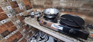 a stove with pots and pans on top of it at Aggarwal guest house lajpat nagar, rooms with private kitchen Android tv wifi and fridge in New Delhi