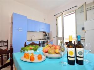 a table with two bottles of wine and fruits and vegetables at Ferienwohnung für 2 Personen 2 Kinder ca 45 qm in Balestrate, Sizilien Nordküste von Sizilien in Balestrate