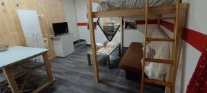 Schlafsaal mit einem Etagenbett und einem Schreibtisch in der Unterkunft Joli studio cosy in Combloux
