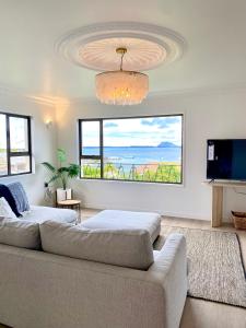 a living room with a couch and a large window at The Views - Omokoroa in Omokoroa
