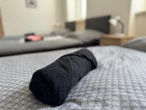 a black towel laying on top of a bed at J&M Apartments in Ústí nad Labem