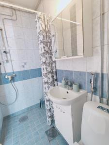 Un baño con lavabo, inodoro y ducha. en Möysä beach apartment, en Lahti