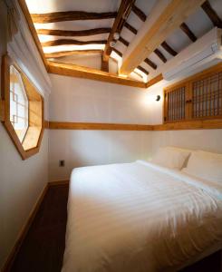 a bedroom with a large white bed with a ceiling at Luxury hanok with private bathtub - SW02 in Seoul