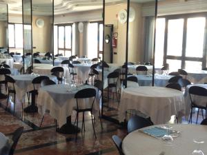 a room full of tables and chairs with white table cloth at Hotel Marcelli in Numana