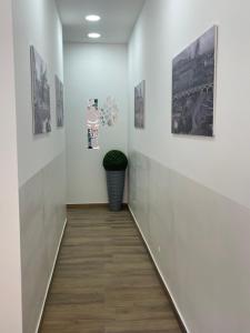 een hal met witte muren en foto's aan de muur bij Calabrò 21 Appartament in Catania