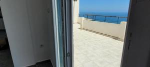 a door to a balcony with a view of the ocean at Immeuble Thala Duplex 135 m² in Tigzirt