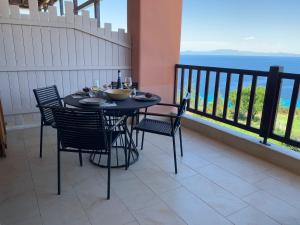 un tavolo e sedie su un balcone con vista sull'oceano di Sunrise Studio Afitos ad Áfitos