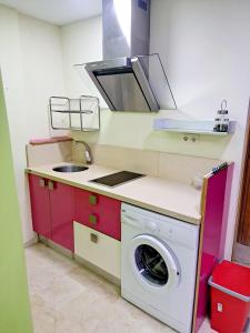 una pequeña cocina con lavadora y fregadero en Confortable flat in the city center, en Ceuta