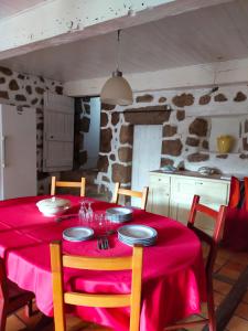 a dining room table with a red table cloth at gîte Lo Jaç de Foart 10 pers. in Bosas