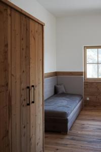 un letto in una camera con un grande armadio in legno di Gut Mitterlehen a Elsbethen