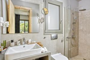 La salle de bains est pourvue d'un lavabo, d'une douche et de toilettes. dans l'établissement Kumquart estate- Orange, à Aspiotádes